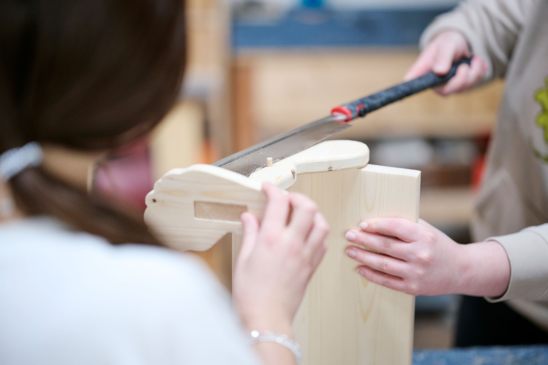 Zwei Personen arbeiten mit Holz