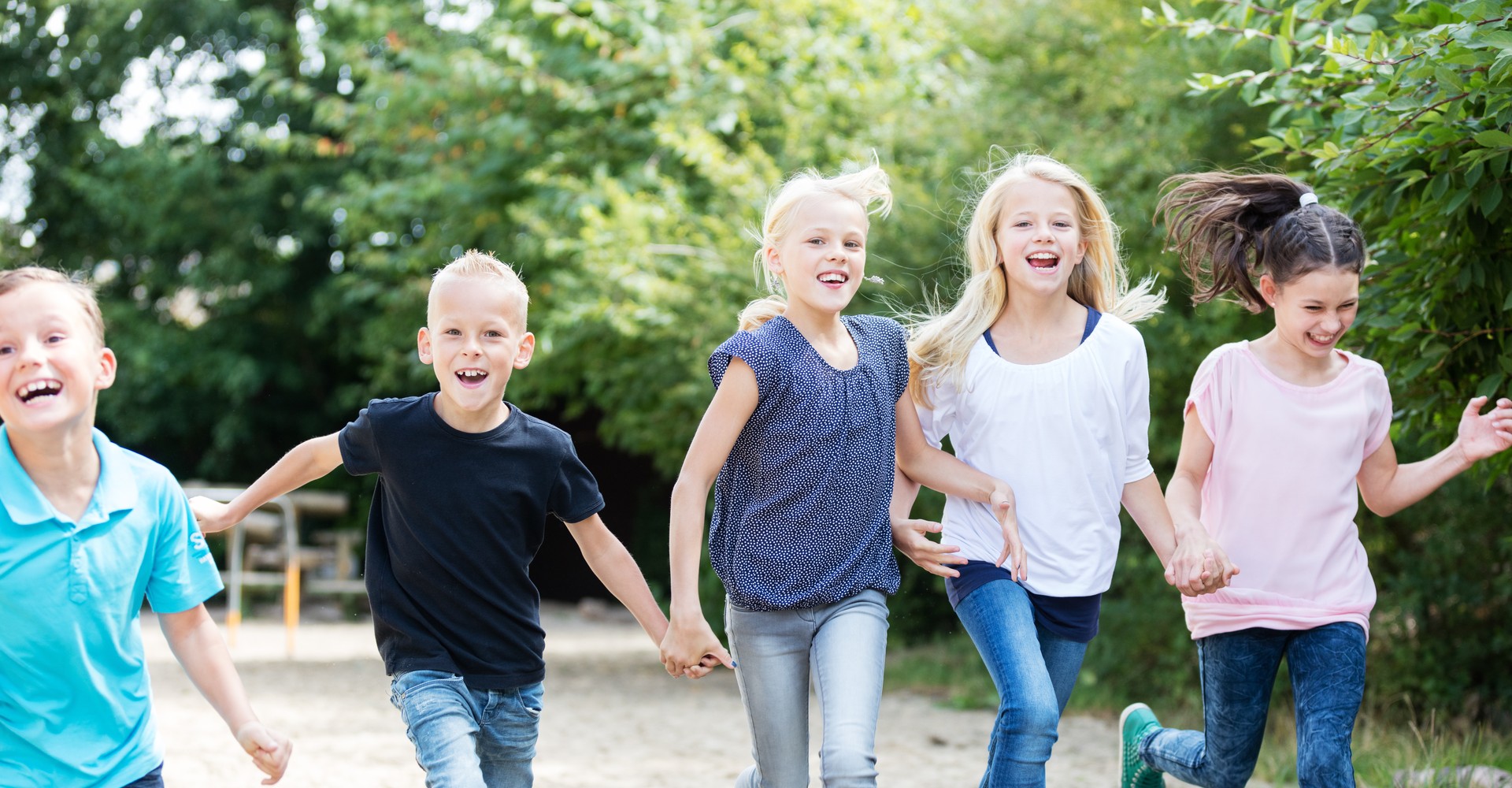Kinder laufen Hand in Hand nebeneinander her