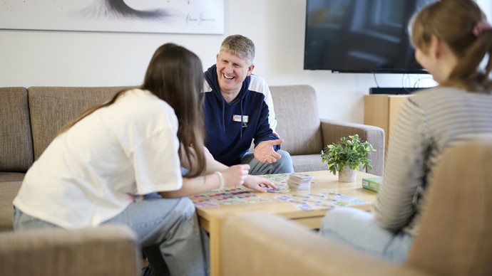 Mehrere Personen sitzen an einem Tisch und besprechen etwas.