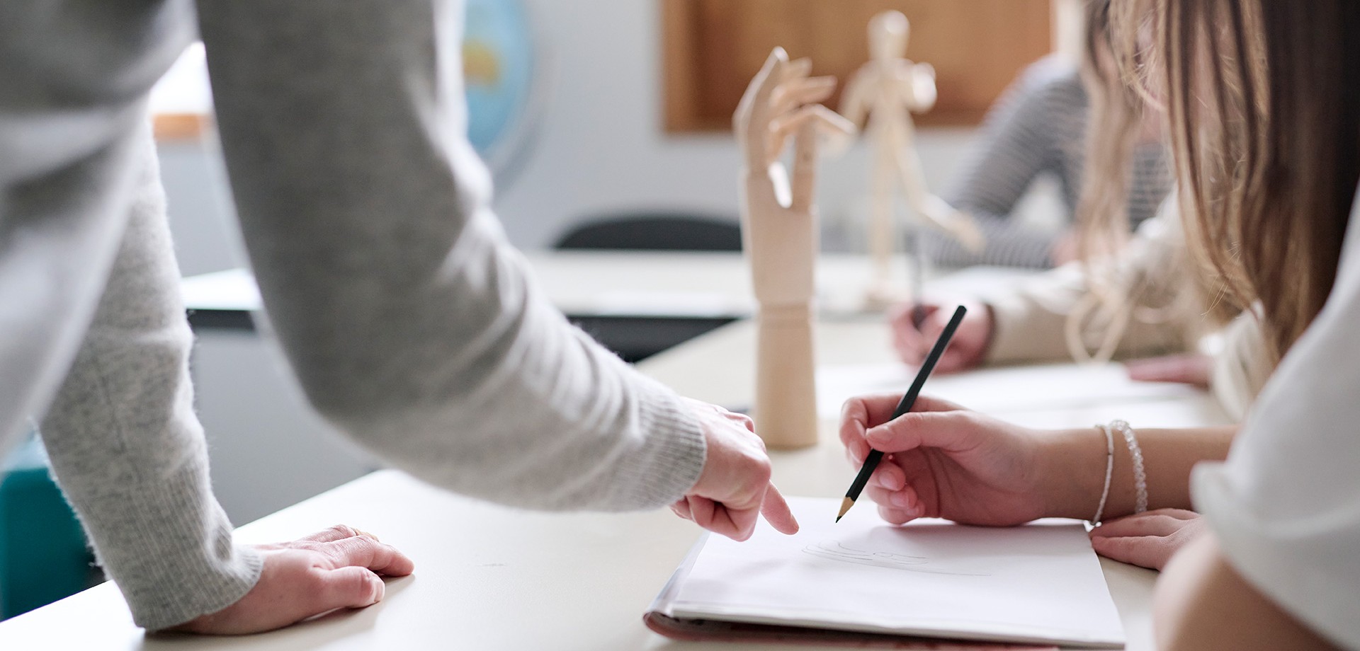 Schülerinnen sitzen in einem Klassenzimmer und arbeiten