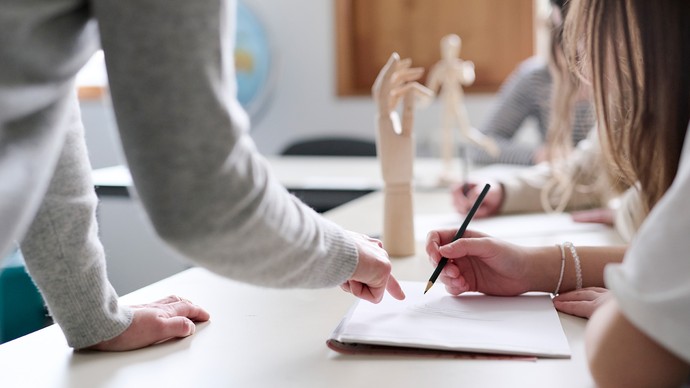 Schülerinnen sitzen in einem Klassenzimmer und arbeiten.
