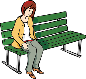 Eine Frau sitzt traurig auf einer Bank, lässt den Kopf hängen, schaut zu Boden und kneift die Lippen zusammen