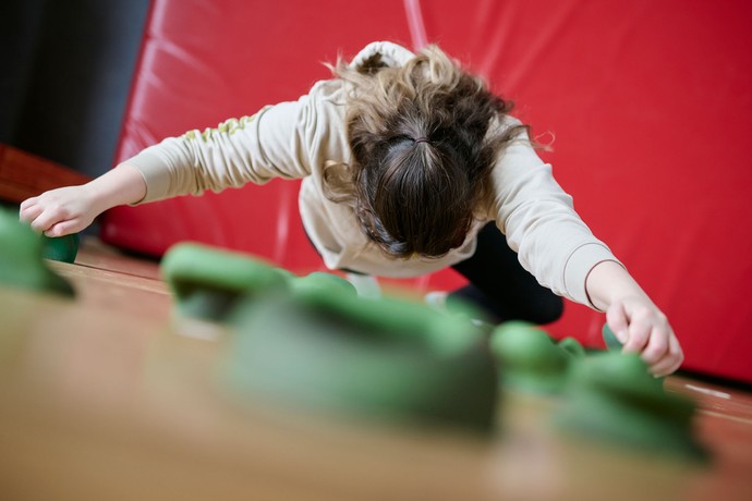 Eine Person klettert an einer Kletterwand