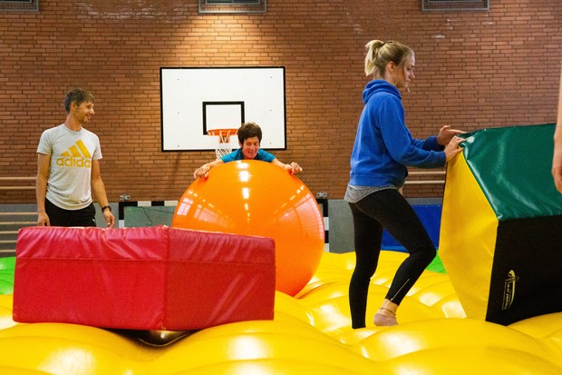 Menschen auf dem Airtramp - einem gelben, riesigen Lufkissen in der Psychomotorik Menschen auf dem Airtramp - einem gelben, riesigen Lufkissen in der Psychomotorik