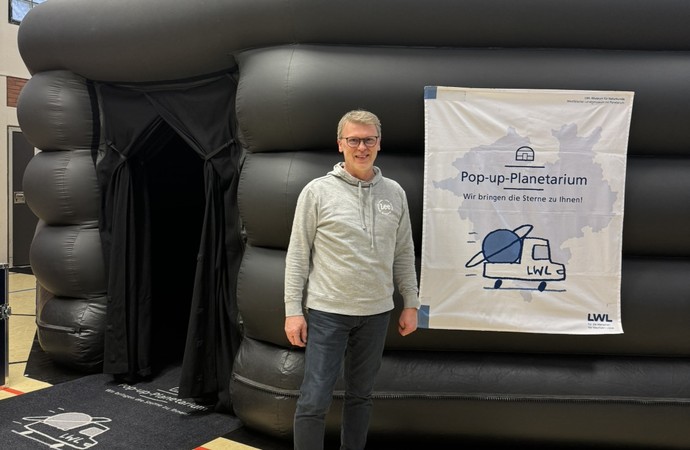 Schulleiter steht vor dem schwarzen Pop-Up-Planetarium.