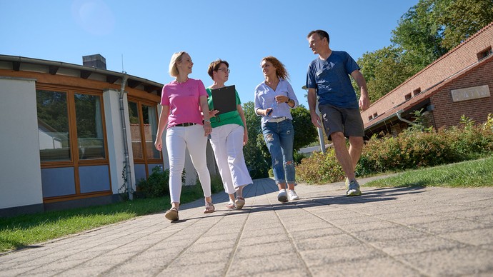 Vier Mitarbeitende laufen nebeneinander her.