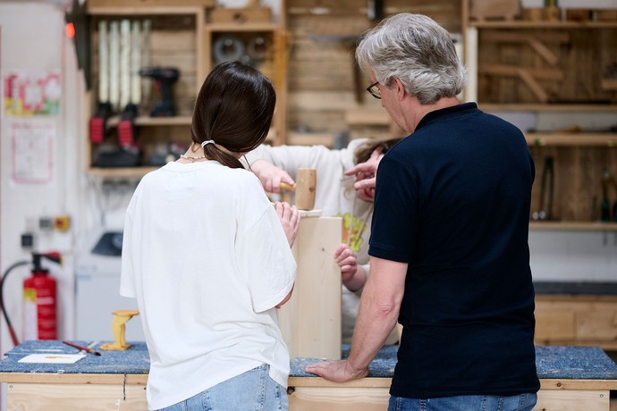 Zwei Personen arbeiten mit Holz