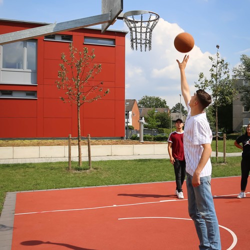 Junger Mann spielt Basketball