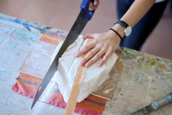 Eine Person arbeitet mit Specksteinen