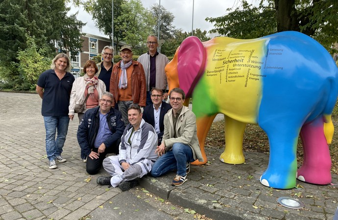 Vertreter unterschiedlicher Einrichtungen stehen vor einem bunt angemalten Elefanten. Vertreter unterschiedlicher Einrichtungen stehen vor einem bunt angemalten Elefanten.