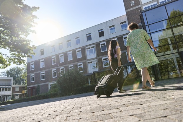Zwei Personen laufen mit einem Koffer in die Klinik