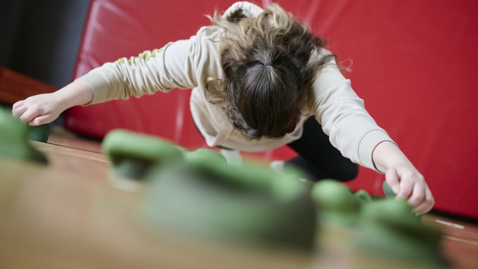 Eine Person klettert an einer Kletterwand