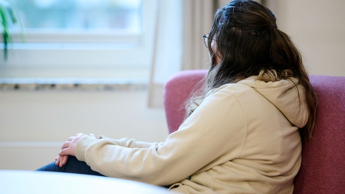 Eine Person schaut aus einem Fenster