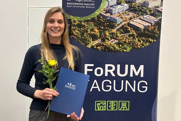 Ein Kollegin hält eine Urkunde in die Kamera