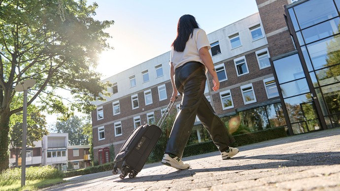 Das Bild eine junge Frau mit einem Koffer